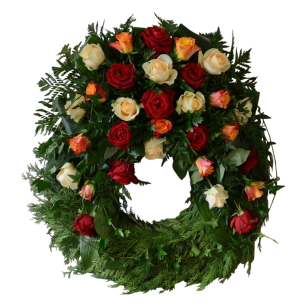En blomsterkrans med röda, vita och orange rosor arrangerade i en cirkel med gröna blad som fyllnad.