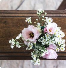 En träkista med en bukett av rosa och vita blommor ovanpå.